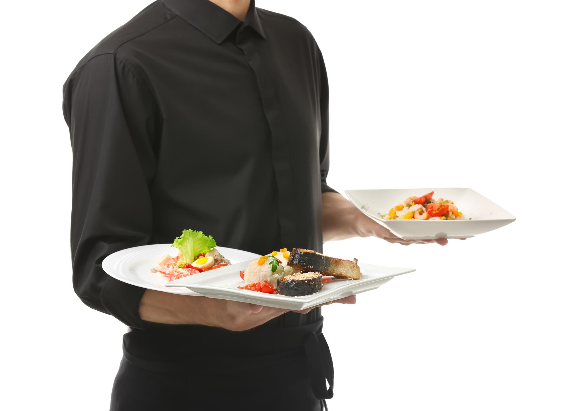 Team serving plates in small restaurant